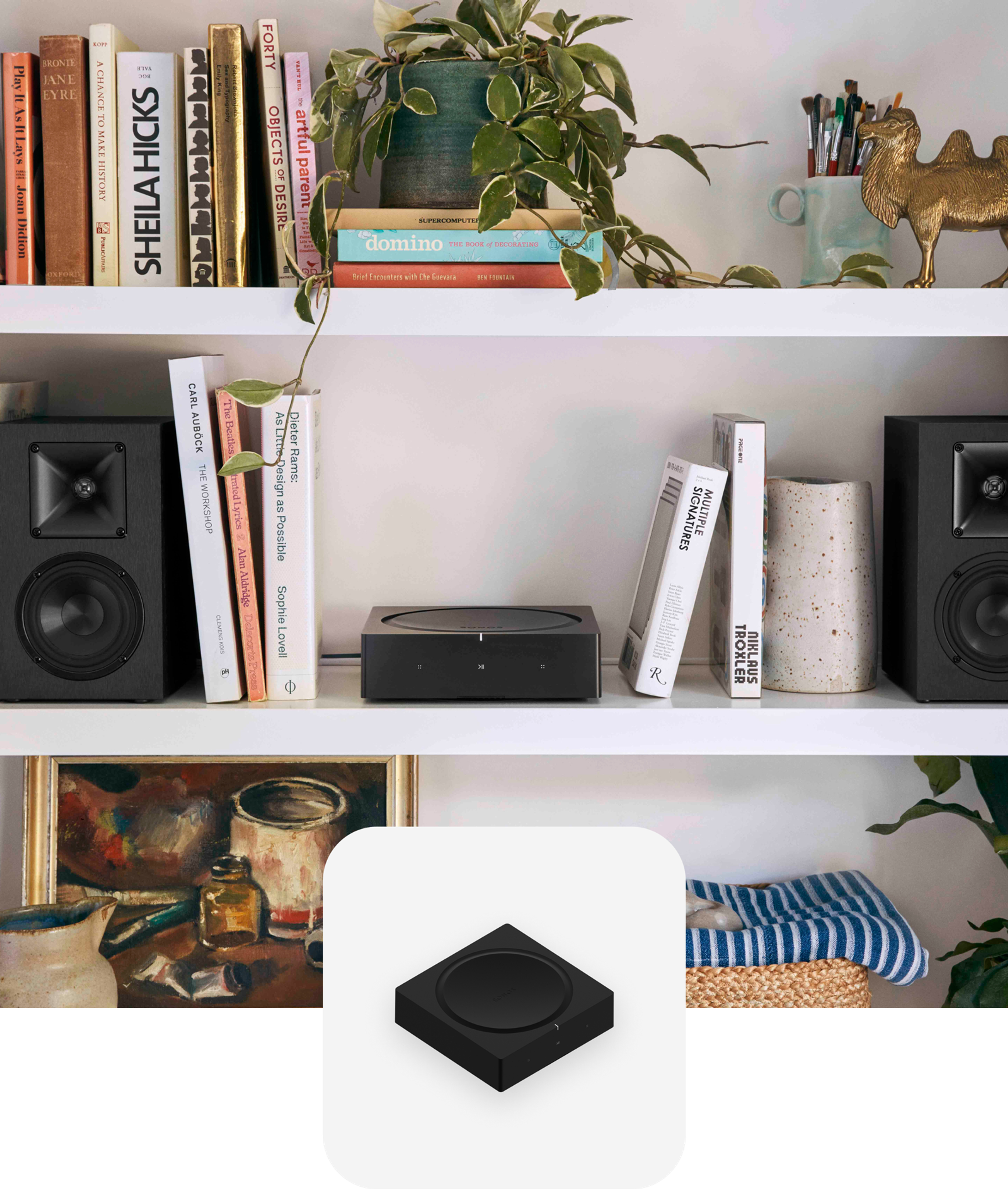 Un Sonos Amp sobre una repisa blanca entre un par de parlantes para repisa