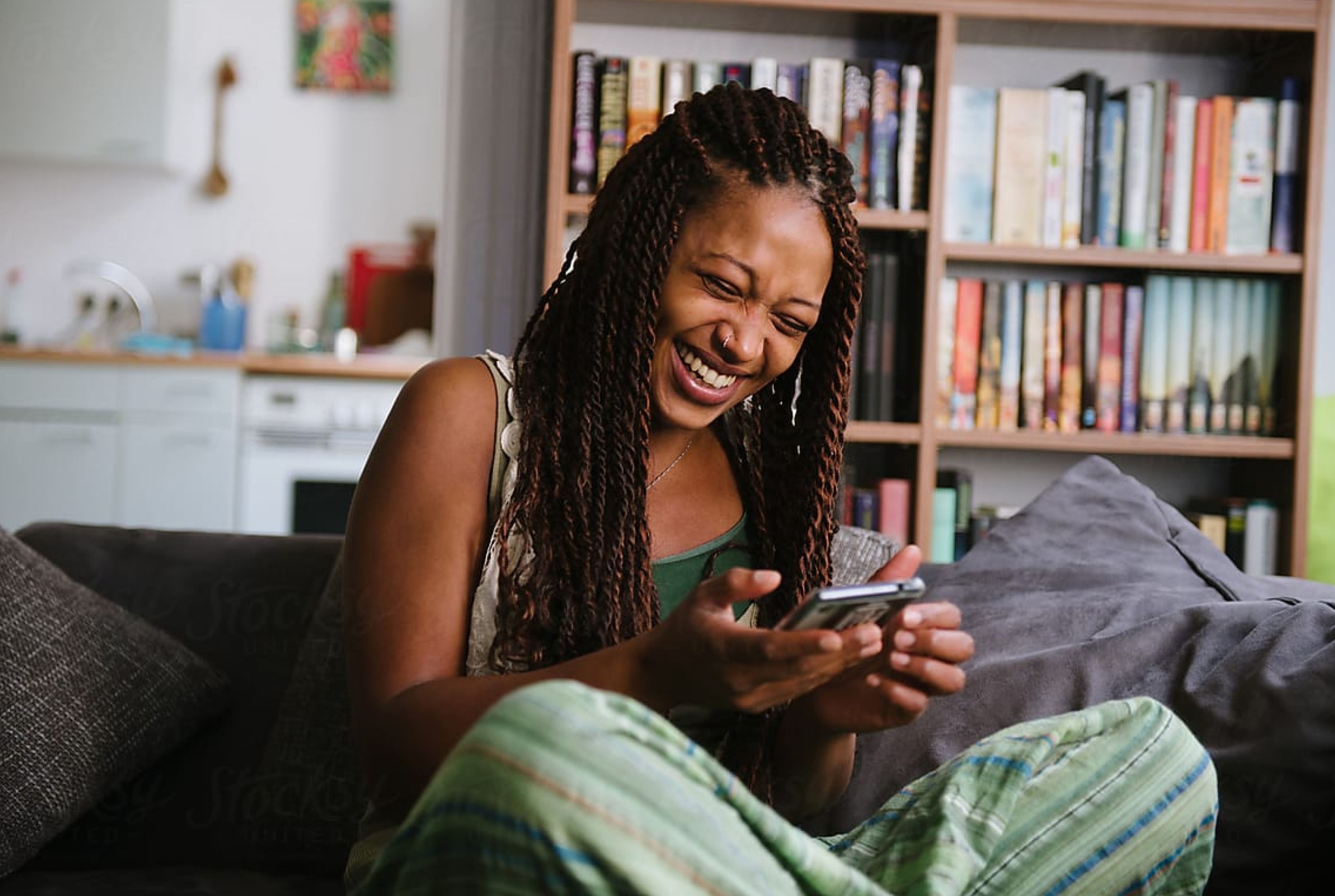 Femme en train de rire avec un smartphone