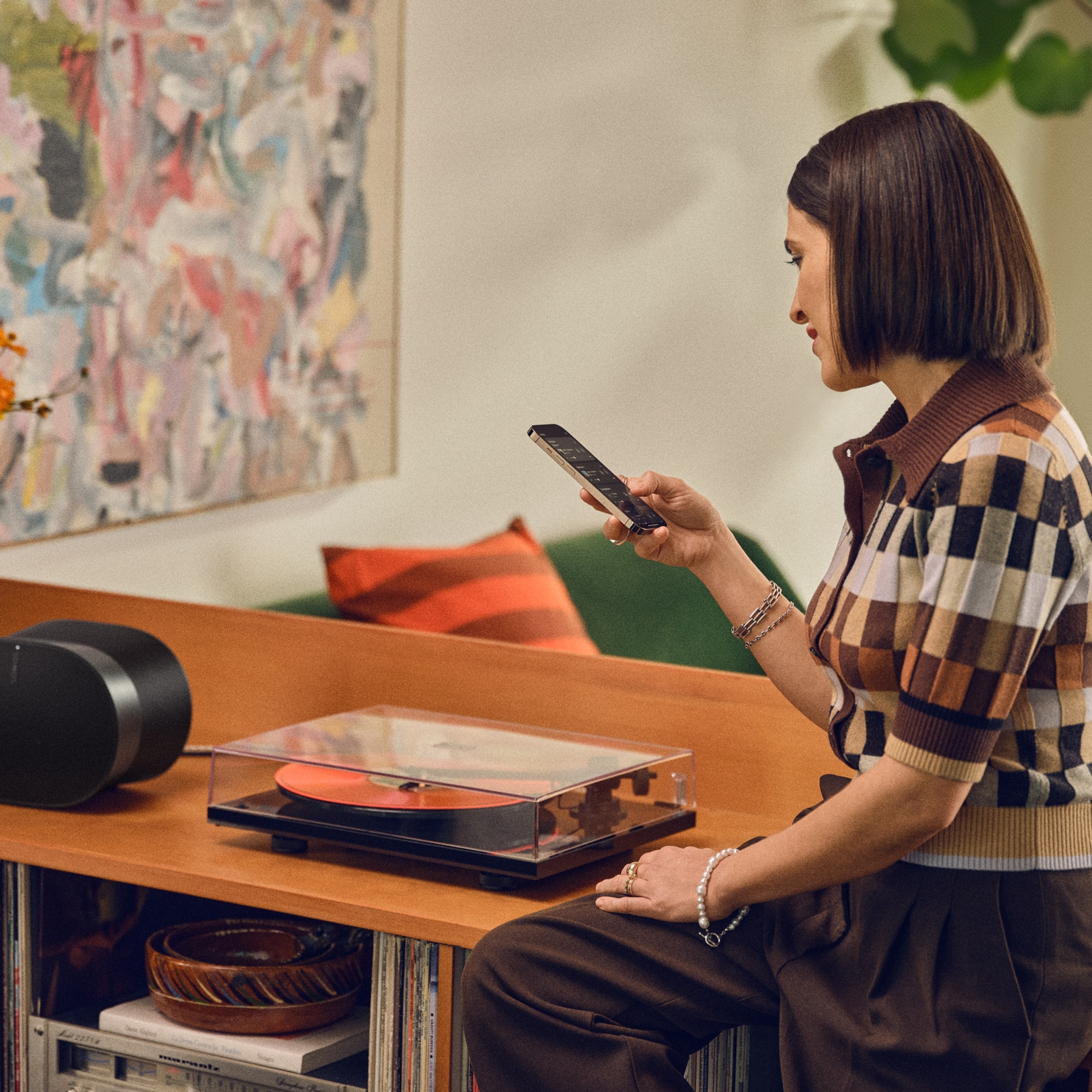 Un utilisateur contrôlant une enceinte Sonos Era 300 connectée à une platine vinyle avec l'application Sonos