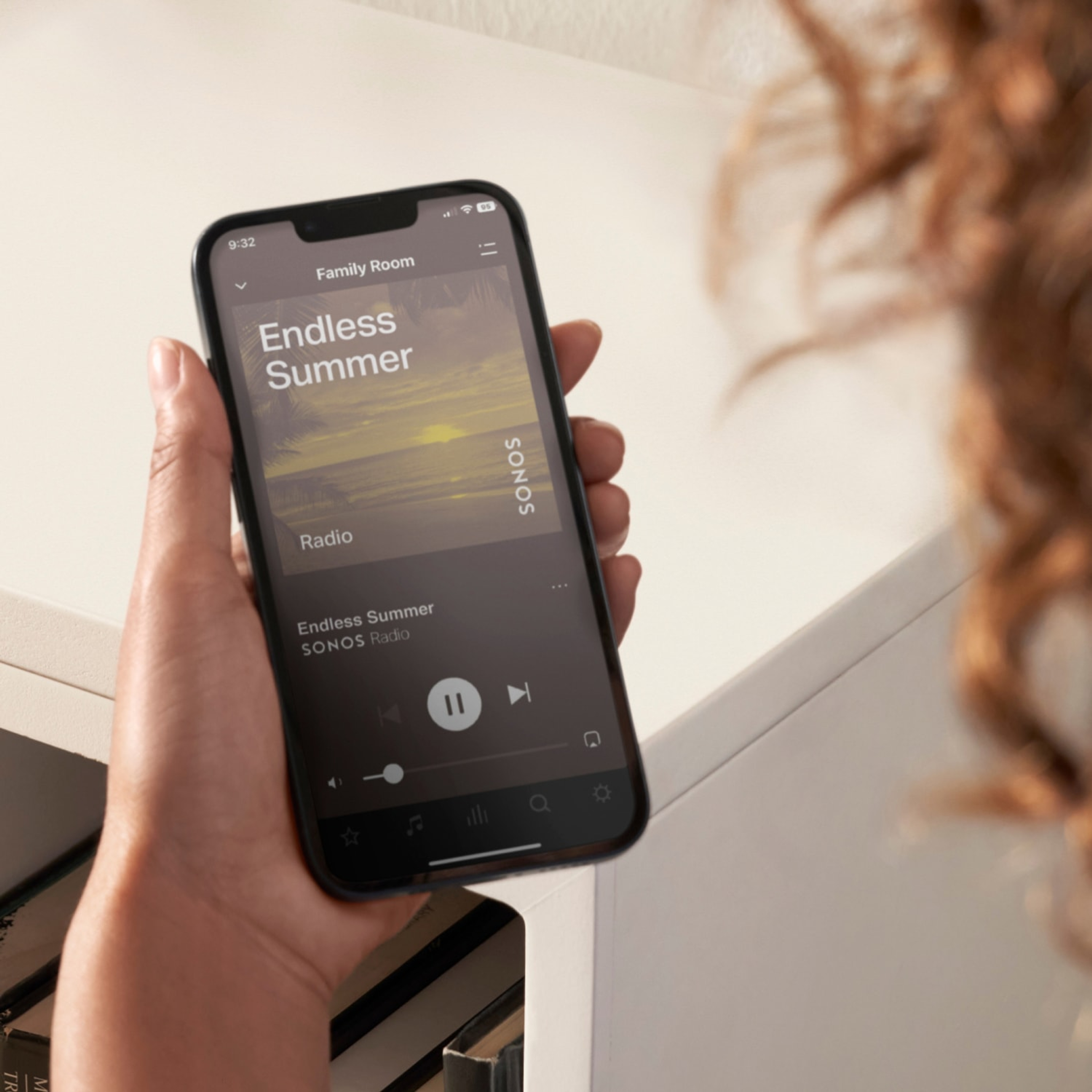 A closeup image of a user's phone as they use the Sonos app to control their Sonos system